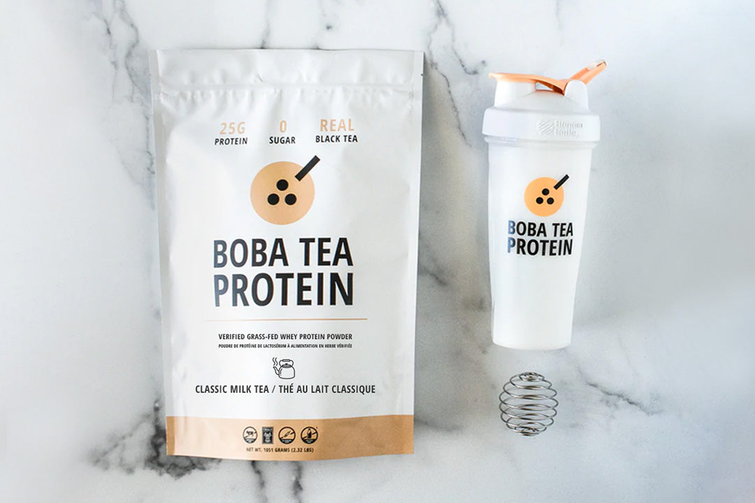 Boba Tea Protein pouch with shaker bottle and metal mixing spring on a marble surface.