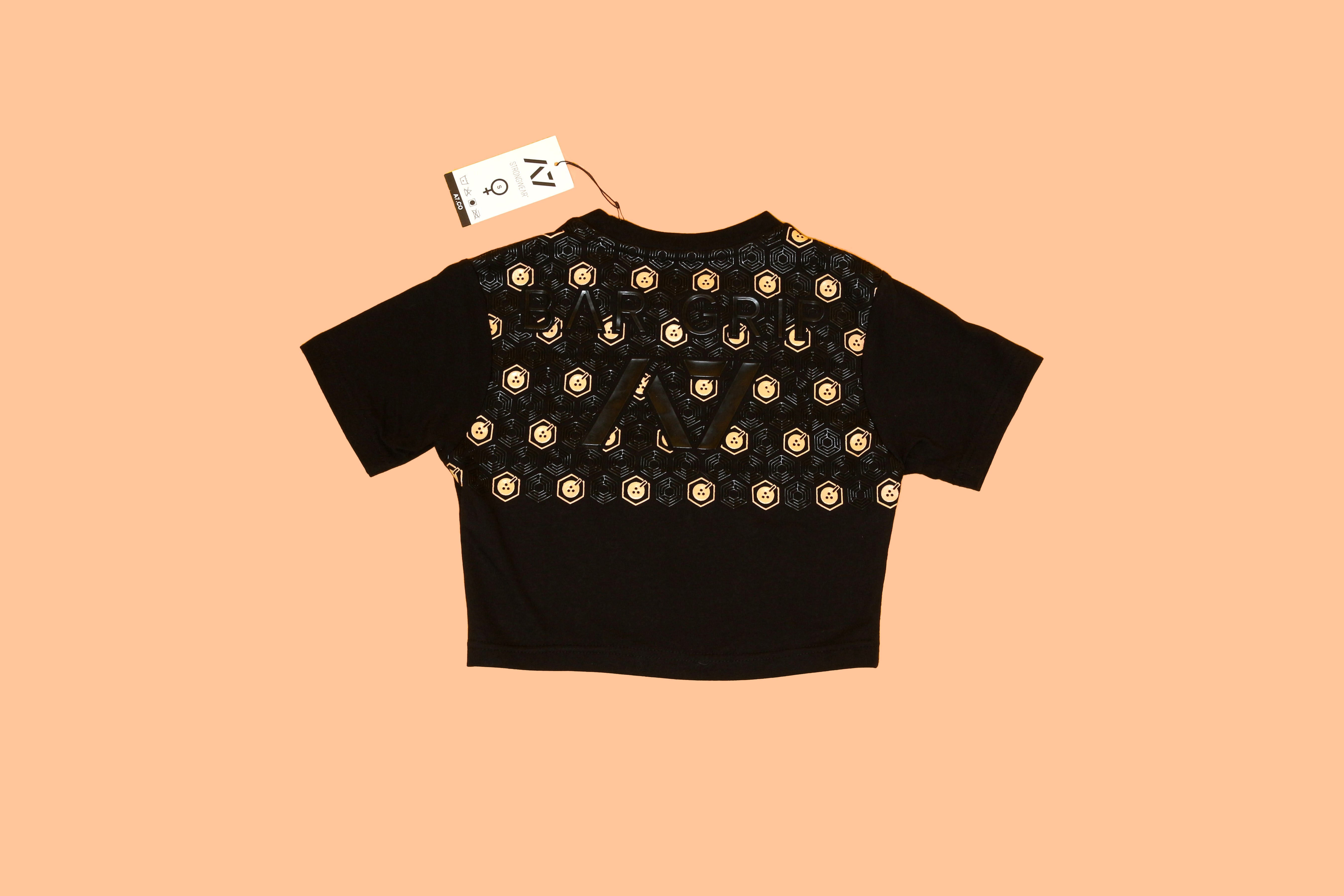 Black crop top with "BOBA TEA PROTEIN" text and a tag, displayed on a peach-colored background.