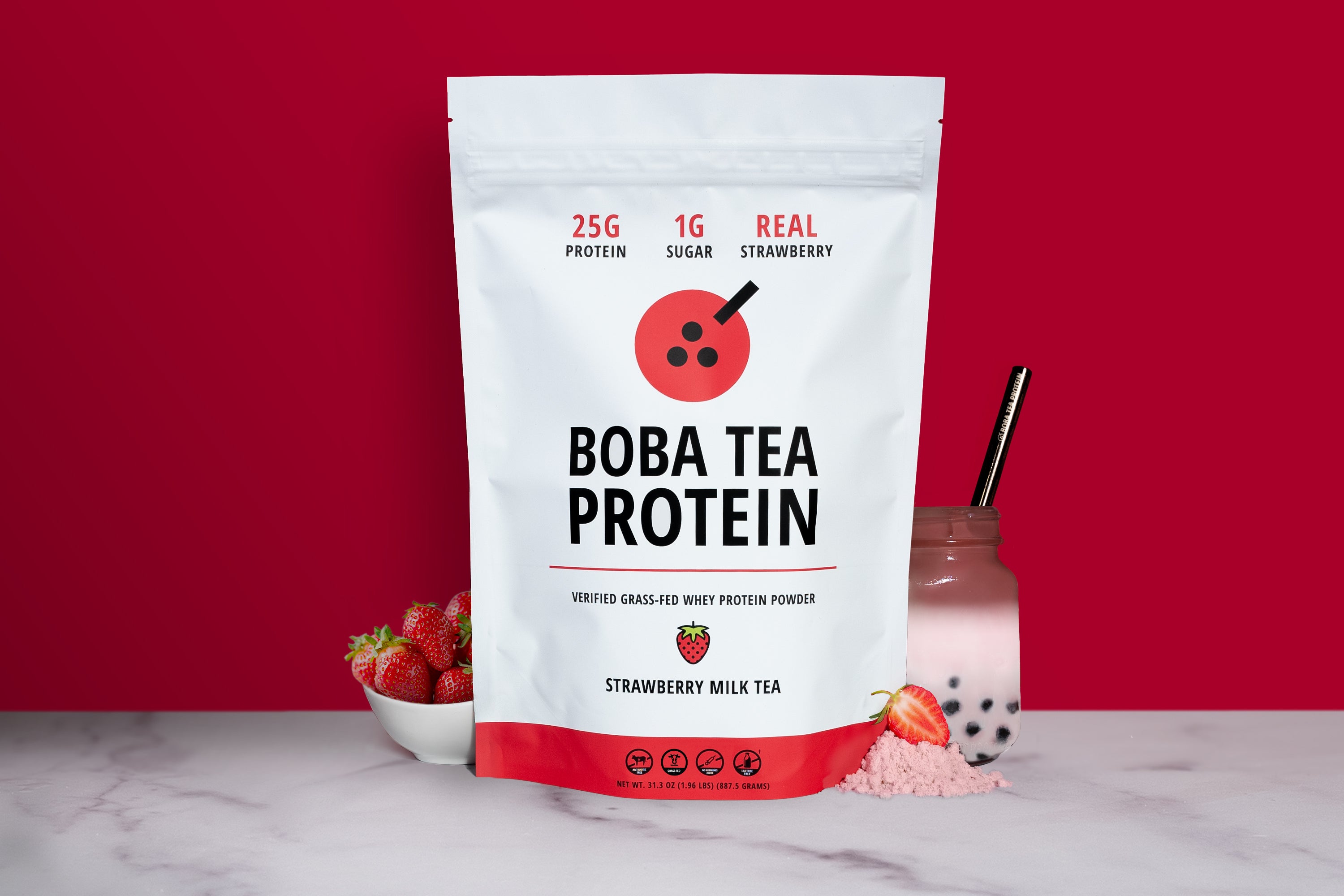Bag of Boba Tea Protein with strawberries and a bowl on a red background
