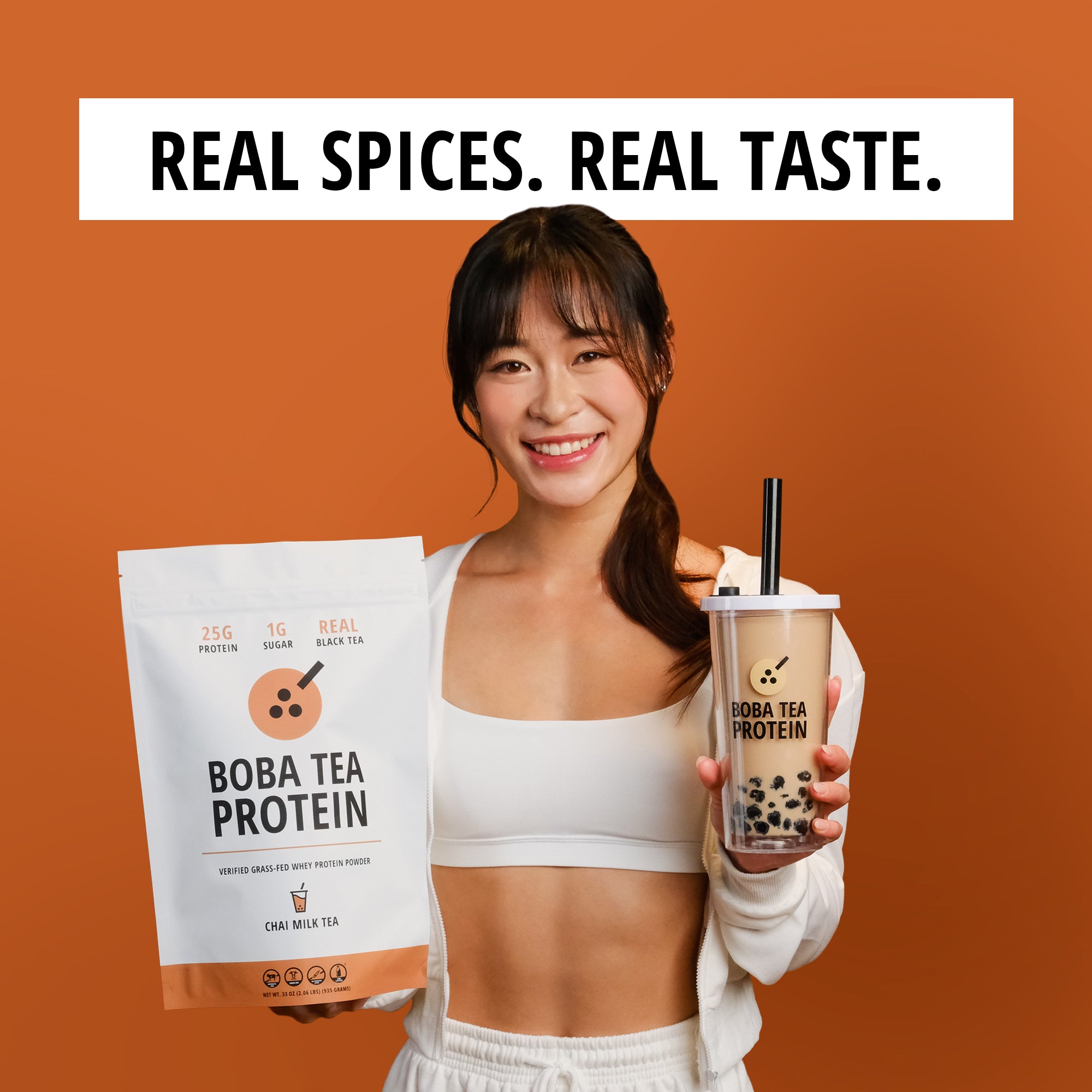 Woman holding Boba Tea Protein packaging and a cup against an orange background with text 'Real Spices. Real Taste.'